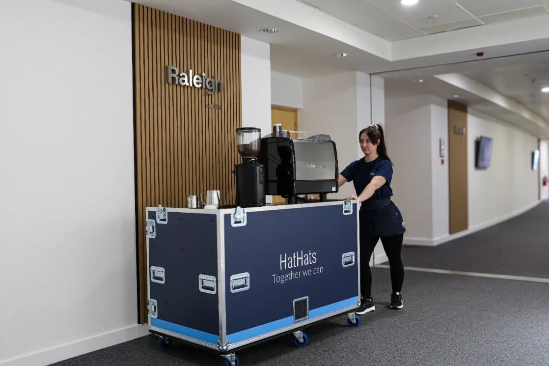 HatHats barista wheeling a mobile coffee cart into an event space